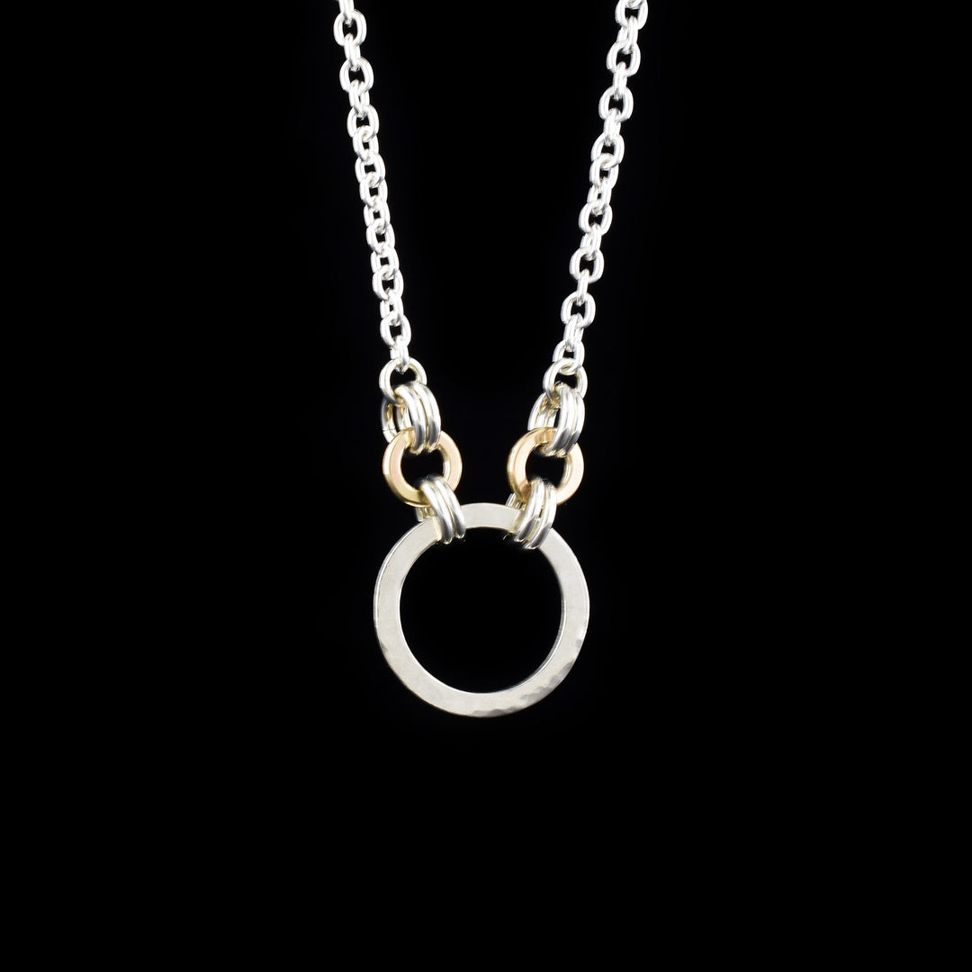 Silver and Gold Kindness Necklace handcrafted by artist Lynda Constantine. Made of sterling silver and 14K gold. Necklace is 18" long and pendant measures 0.94" x 0.63" including smaller rings.