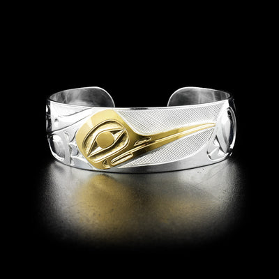 Hummingbird cuff bracelet hand-carved by Indigenous artist Ivan Thomas. Made of sterling silver and 14K gold. Bracelet is 6.19" long with 0.75" gap and has width of 0.75".