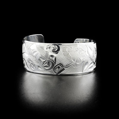 Hummingbirds and morning glories bracelet hand-carved by Tlingit artist Fred Myra. Made of sterling silver. Bracelet is 6.25" long with 1.13" gap and has width of 1".