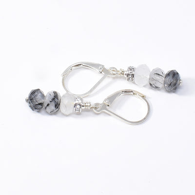 Lever back earrings handcrafted by artist Karley Smith. Made of sterling silver, tourmalinated quartz and clear quartz. Ear hooks are sterling silver. Each earring measures 1.35" x 0.20" including hook.