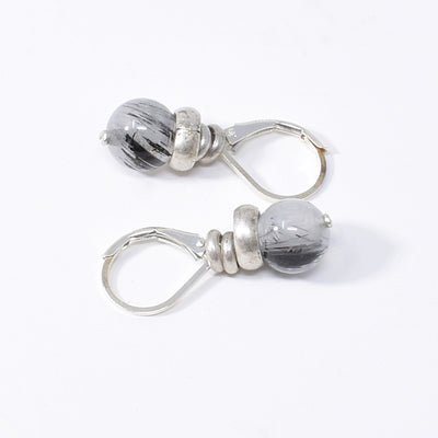 Unique lever back earrings handcrafted by artist Karley Smith. Made of sterling silver, antique silver and tourmalinated quartz. Ear hooks are sterling silver. Each earring measures 1" x 0.35" including hook.