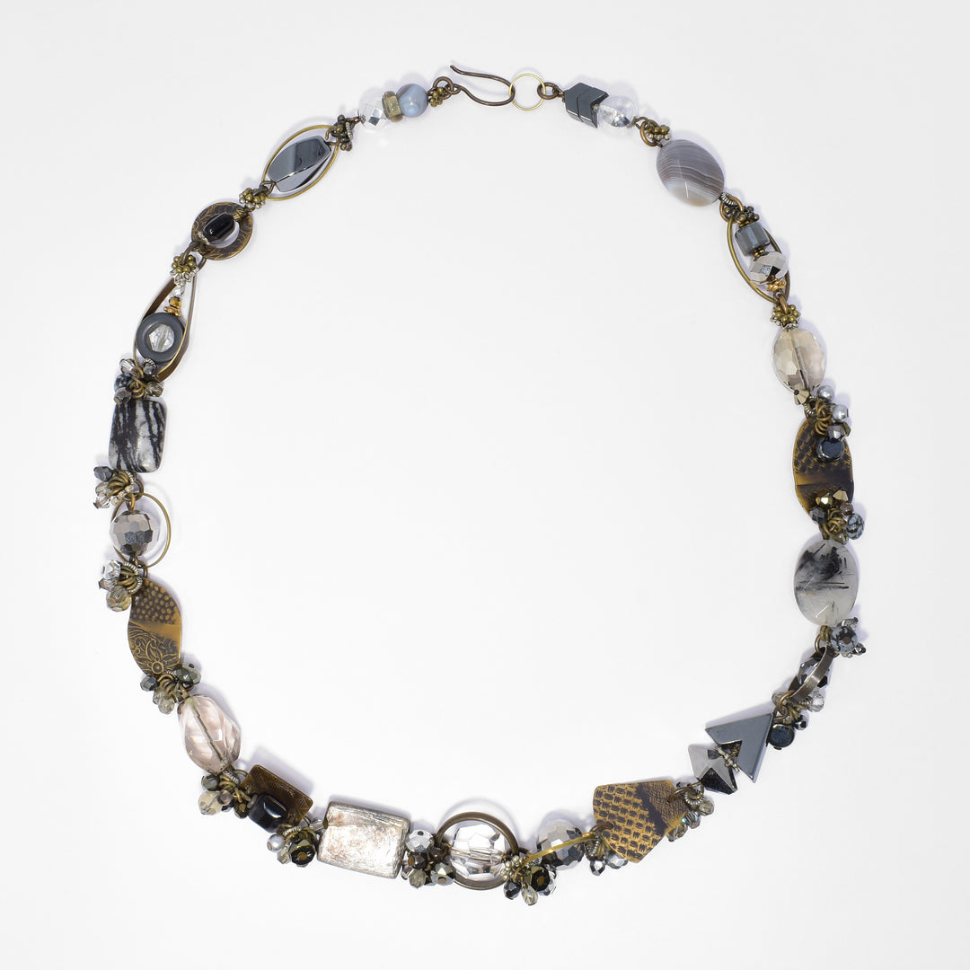 Made of Austrian crystal, BC artist studio glass, handworked brass, lampworked glass, snowflake obsidian, tourmalinated quartz, hematine, agate, glass, jasper and hematite. 22" long.