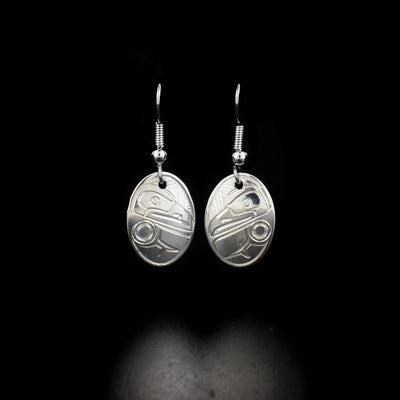 Delicate oval raven earrings hand-carved by Kwakwaka'wakw artist Norman Seaweed. Made of sterling silver. Each earring measures 1.4" x 0.5" including hook.