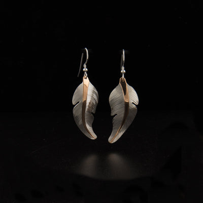 Sterling silver and 18K gold plating heron feather earrings hand-carved by Tlingit artist Fred Myra. Each earring measures 2" x 0.56" including hook.