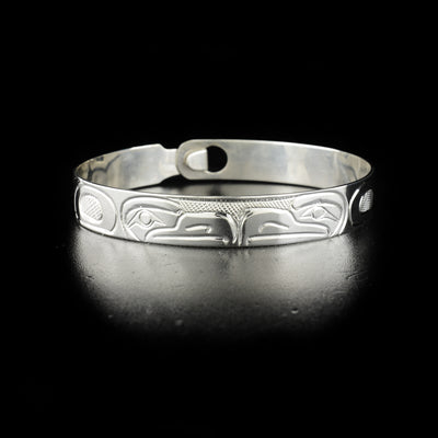 Double eagle clasp bracelet hand-carved by Kwakwaka'wakw artist Norman Seaweed. Made of sterling silver. Bracelet has circumference of 7.63" when clasped shut. The clasp design makes it fit like a smaller style bangle and can fit various wrist sizes. Bracelet has width of 0.38".