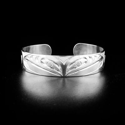 Sleek double raven bracelet hand-carved by indigenous artist Ivan Thomas. Made of sterling silver. Bracelet is 6.5" long with 0.7" gap and has width of 0.5".