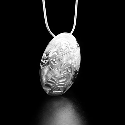 Detailed oval heron pendant hand-carved by Tlingit artist Fred Myra. Made of sterling silver. Pendant measures 1.88" x 1". Hidden bail on back. Chain not included.