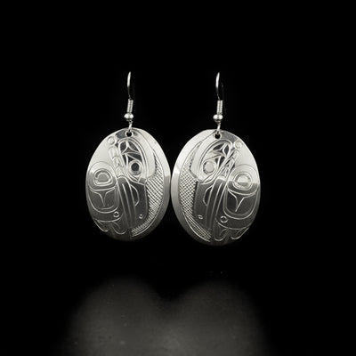 Oval raven earrings hand-carved by Kwakwaka'wakw artist Don Lancaster. Made of sterling silver. Each earring measures 2" x 1" including hook.