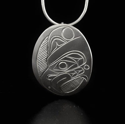 Oval thunderbird pendant hand-carved by Kwakwaka'wakw artist Don Lancaster. Made of sterling silver. Pendant measures 1.50" x 1". Hidden bail on back. Chain not included.
