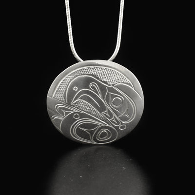 Sleek round eagle pendant hand-carved by Kwakwaka'wakw artist Don Lancaster. Made of sterling silver. Pendant has diameter of 1.25". Hidden bail on back. Chain not included.