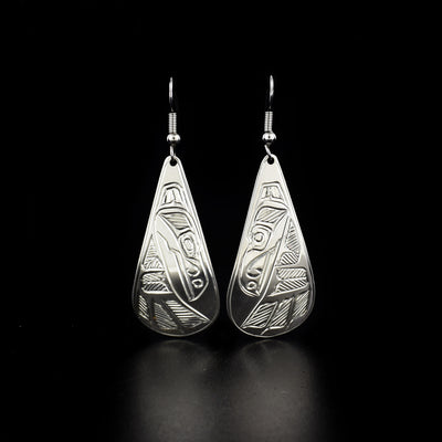 Teardrop raven earrings hand-carved by Heiltsuk artist Ivan Wilson. Made of sterling silver. Each earring measures 2.30" x 0.80" including hook.