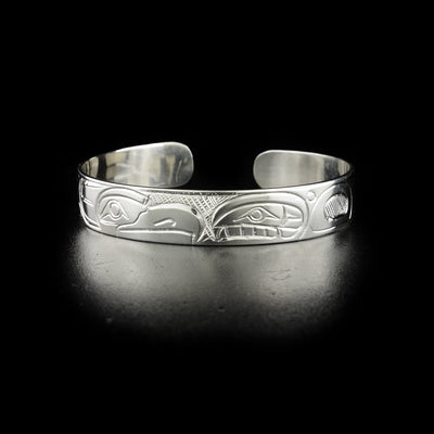 Eagle and orca cuff bracelet hand-carved by Kwakwaka'wakw artist Norman Seaweed. Made of sterling silver. Bracelet is 6.30" long with 0.60" gap and has width of 0.38".