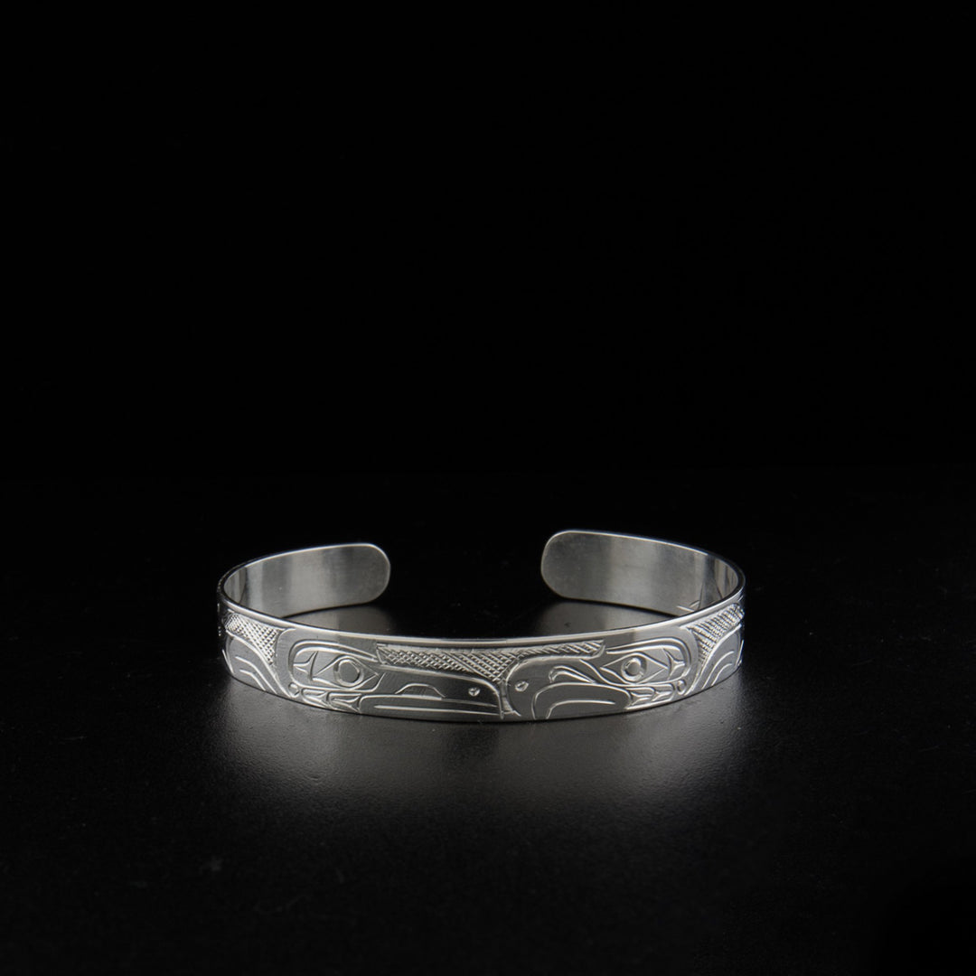 Sterling silver raven and eagle bracelet hand-carved by Kwakwaka'wakw artist Don Lancaster. 6.63" long with 0.88" gap. 0.38" wide.