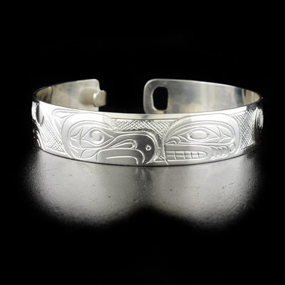 Thunderbird and orca clasp bracelet hand-carved by Kwakwaka'wakw artist Don Lancaster. Made of sterling silver. Bracelet has circumference of 7.50" when clasped shut and width of 0.50". The clasp design makes it fit like a smaller style bangle and can fit various wrist sizes.