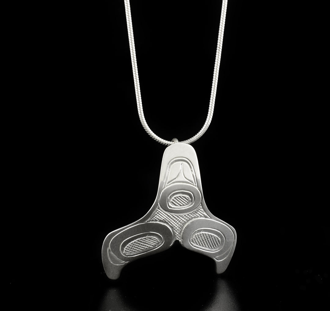 Detailed whale tail pendant hand-carved by Kwakwaka'wakw artist Don Lancaster. Made of sterling silver. Pendant measures 1.50" x 1.31". Hidden bail on back. Chain not included.