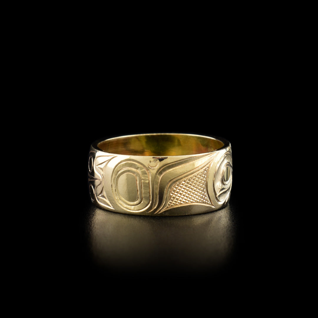 Left angle photo of the ring shows carved designs representing the wing of the hummingbird.