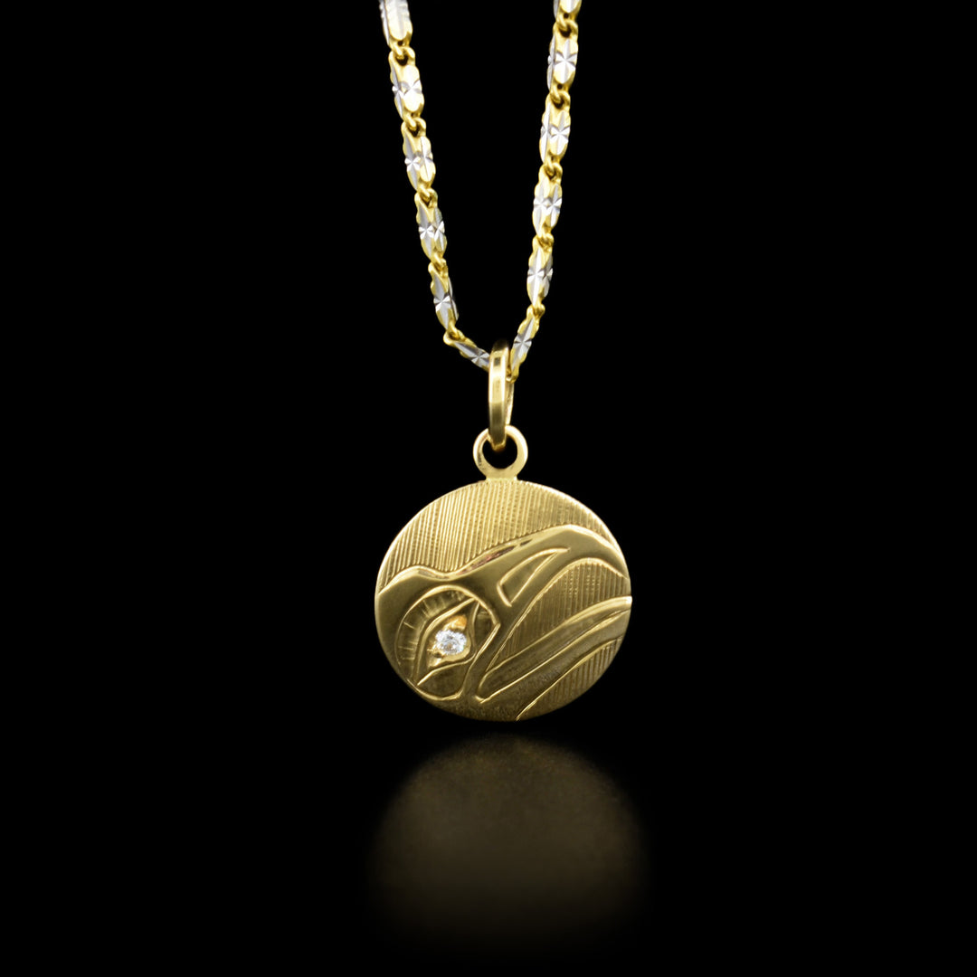 This raven pendant has the profile of a raven's head facing to the right with an open beak and a diamond in its eye.