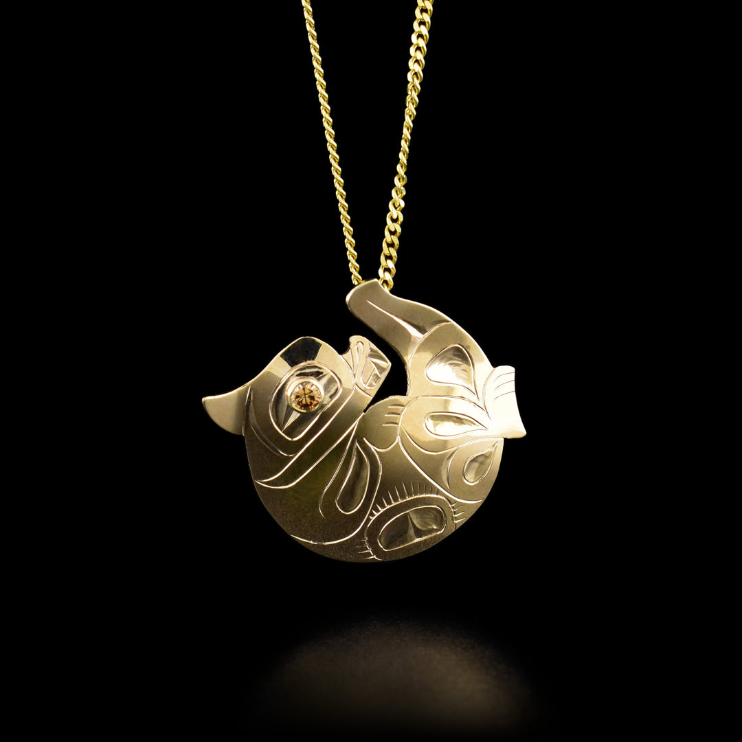 This otter necklace is in the shape of an otter laying on its back with its tail up. There is a yellow diamond in its eye.