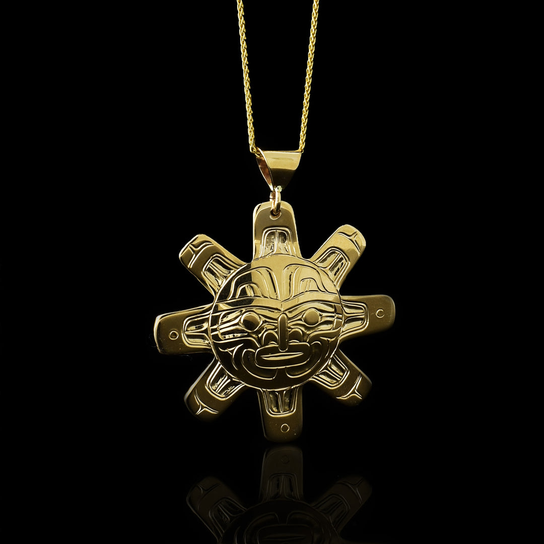 Photo showing the sun pendant hanging from a gold chain.