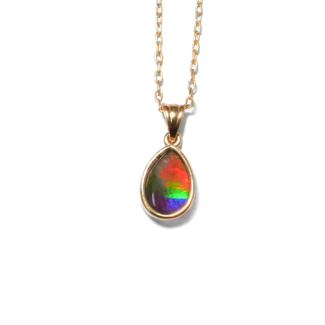 This ammolite pendant is teardrop in shape and has a triangular bail. The colours of the ammolite include red, orange, lime green, blue, and violet.