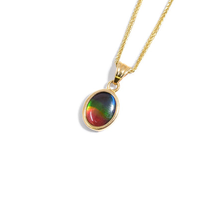 This ammolite pendant is oval in shape and has a large, triangular bail at the top. The colours include blue at the top, green under, yellow, and finally red at the bottom.