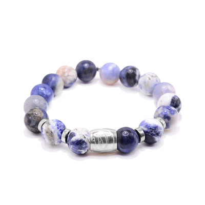 This jasper bead bracelet has sphere shaped beads made from jasper. The beads are multicolored showing black, white, blue and purple. There is a sterling silver spirit bead with the head of the Eagle carved into it and sterling silver spacers between the beads by it.