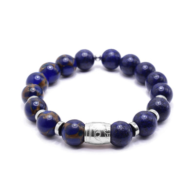 This gemstone charm bracelet has small, sphere shaped beads made from jasper and reconstructed lapis. The jasper beads have a blue color with brown highlights. There is a sterling silver spirit bead in the center of the piece with a depiction of the head of the Raven carved into it. There are round, flat silver spacers (three on either side of the spirit bead).