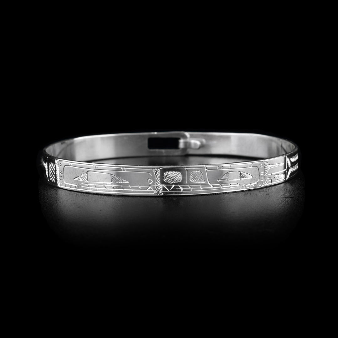 This sterling silver cuff bangle bracelet has a thin band with a clasp in the back. The Orca and the Bear legends are carved into the band and there heads meet at the front of the band.