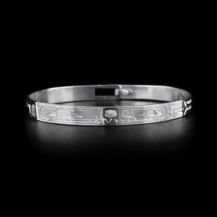 This sterling silver cuff bangle bracelet has a thin band with a clasp in the back. The Orca and the Bear legends are carved into the band and there heads meet at the front of the band.