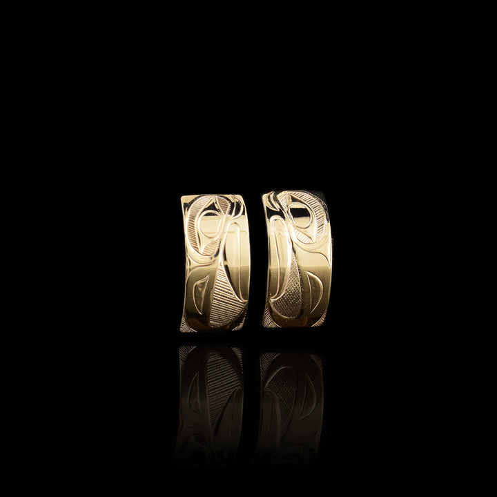 These 14K gold half hoop earrings are wide and have depictions of the head of the Eagle carved into the surface of them.