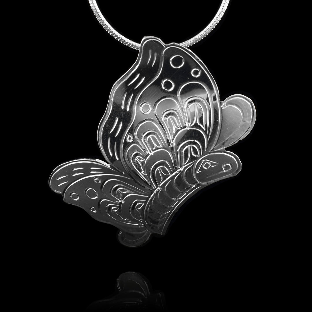 This butterfly silver pendant is large, made from sterling silver and has the shape of the butterfly. There are carvings on the piece detailing the patterns of the wings, texture of the body and small face.