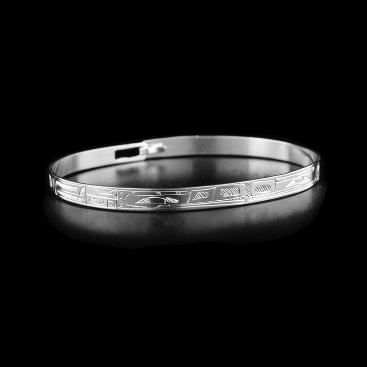 This Wolf and Bear bracelet has a thing, sterling silver band with a clasp in the back. There is a Wolf and a Bear legend carved into the band and their heads meet at the front of the piece. Their bodies extend around the rest of the band.