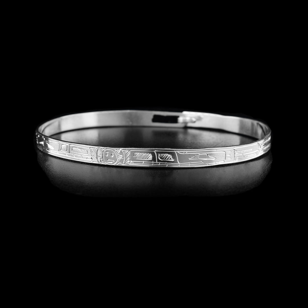 This thin bangle bracelet has a thin band made from sterling silver with a clasp in the back. There are carvings on the surface of the band showing two Wolves with their heads meeting at the front of the band. In between their heads, the moon is shown.