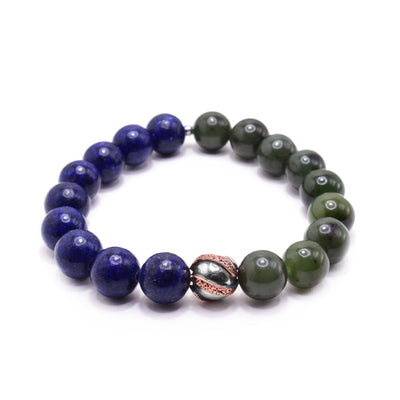 This jade charm bracelet has small, sphere beads made from lapis lazuli and BC jade. Half of the piece is the lapis lazuli and the other half, the jade. There is a copper charm bead in the center of the piece with three textured bands on the surface of it.