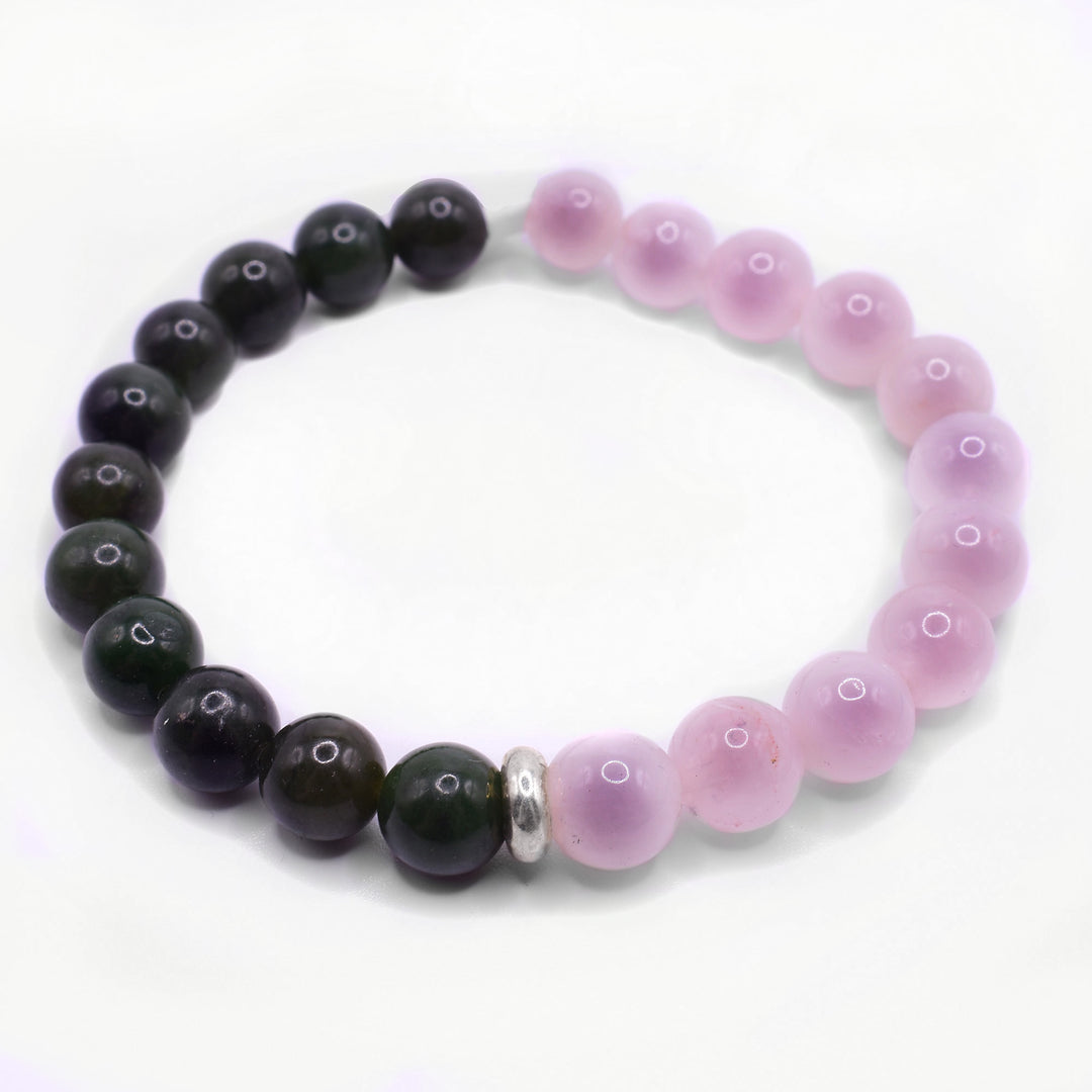 This bracelet with rose quartz has small, sphere shaped beads that run around the entire piece. Half the bracelet is made from BC jade beads and the other half has rose quartz. There is a small, sterling silver charm in between the two materials.