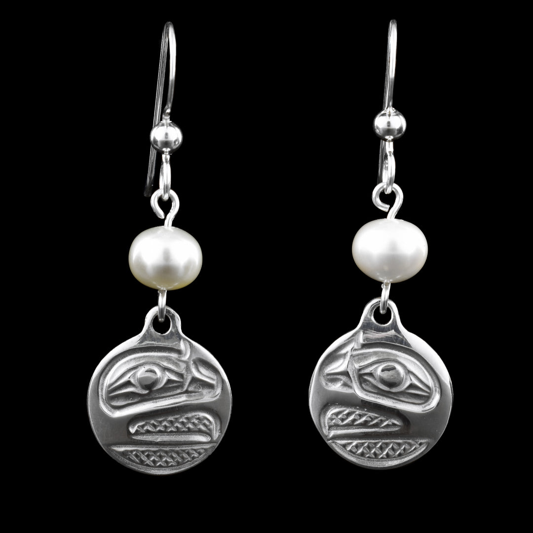 These sterling silver Raven earrings have circle shaped hangs with pearls under the hangs and below the pearls a depiction of the side profile of he Raven's head cast into the hangs. The eye is large and its beak is open with cross hatching designs made in the background of the scene.