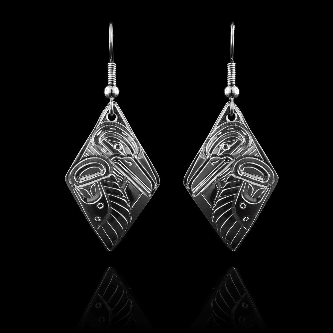 These Hummingbird dangle earrings have long, diamond shaped hangs made from sterling silver. There are depictions of the Hummingbird in side profile with their head facing down at the top and their wing, with feather details, running down the side of the hangs.