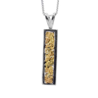 The gold nugget pendant has a sterling silver ring that is shaped like a long, thin rectangle. The pendant is completely filled with 22K gold nuggets.