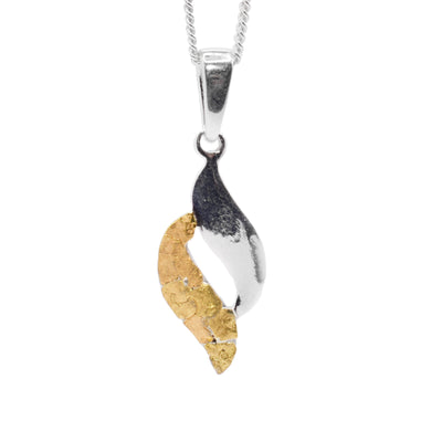This gold nugget pendant is made from two wavy pieces that are connected to each other to form a teardrop shape. One piece is sterling silver and the other is 22K gold nugget and there is a gap in the middle.
