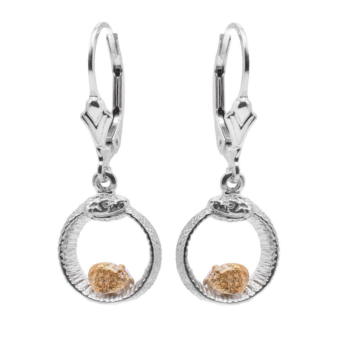 These Ouroboros earrings have circle hoop hangs dangling from lever back hooks. The hoops are shaped like snakes with their tail curled up into their mouth. There are scales and details like the eyes and mouth carved into the hangs. At the bottom of the hoops, there are single, 22K gold nuggets.