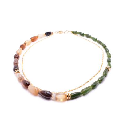 This jade and gold necklace has teardrop shaped beads made from dyed agate and BC jade. The beads star smaller and get larger at the bottom of the piece. Half the necklace is agate and the other half is jade. There are circle spacers made from 14K gold fill and are placed in three places around it. There is a dainty gold filled chain seperate from the gemstone beaded chain.