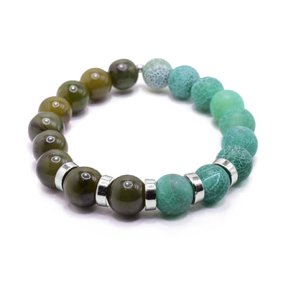 This jade bead bracelet has small, sphere shaped beads made from BC jade and dyed green agate. Half the piece is jade and the other is agate. There are five rhodium plated spacers between the beads in the center of the piece. The spacers are round and flat.