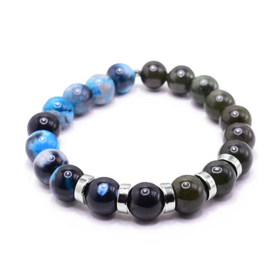 This jade charm bracelet has small, sphere shaped beads made from BC jade and dyed blue and black agate. Half the piece is jade and the other half is the dyed agate. There are small, round and flat spacers made from rhodium plated material that are placed between the beads. There are only 5 spacers.