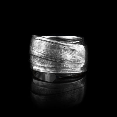 These large sterling silver rings have flowing designs on the surface of it. The piece is made by casting metal into wax so it mimics the appearance of it wax mold. The ring is chunky and has a large gauge.