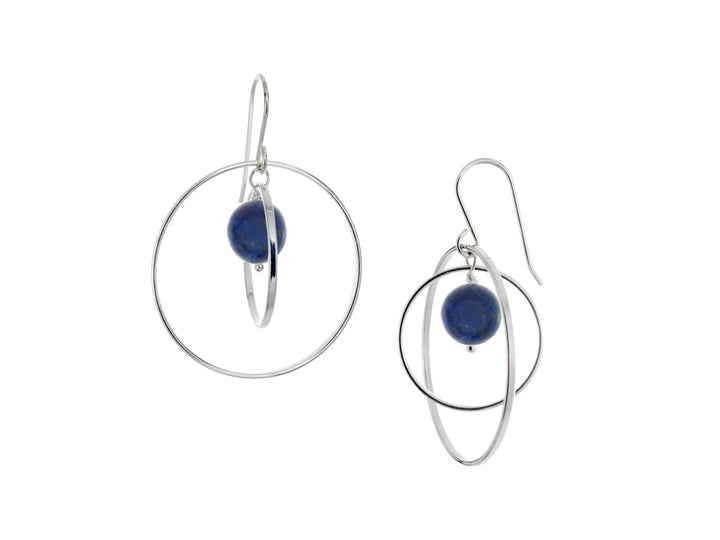 These hoop dangle earrings have large, sterling silver hoops with a smaller one inside of it. In the middle is a sphere shaped lapis lazuli bead. All of these pieces are dangling and fit inside each other. The hoops are free to orbit around the gem.