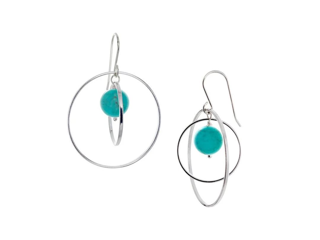 These hoop dangle earrings have large, sterling silver hoops with a smaller one inside of it. In the middle is a sphere shaped turquoise bead. All of these pieces are dangling and fit inside each other. The hoops are free to orbit around the gem.