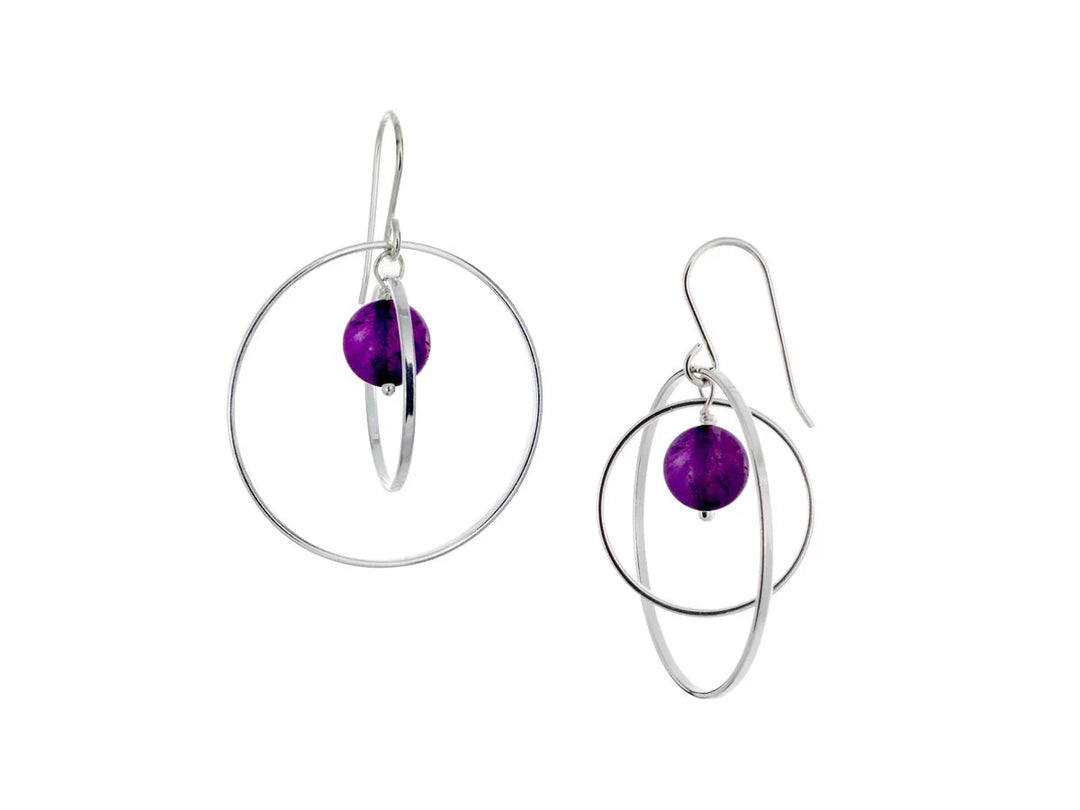 These hoop dangle earrings have large, sterling silver hoops with a smaller one inside of it. In the middle is a sphere shaped amethyst bead. All of these pieces are dangling and fit inside each other. The hoops are free to orbit around the gem.