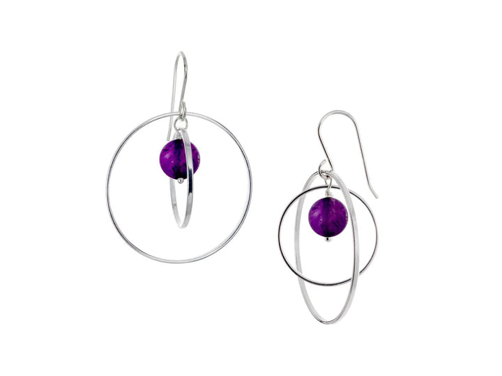 These hoop dangle earrings have large, sterling silver hoops with a smaller one inside of it. In the middle is a sphere shaped amethyst bead. All of these pieces are dangling and fit inside each other. The hoops are free to orbit around the gem.
