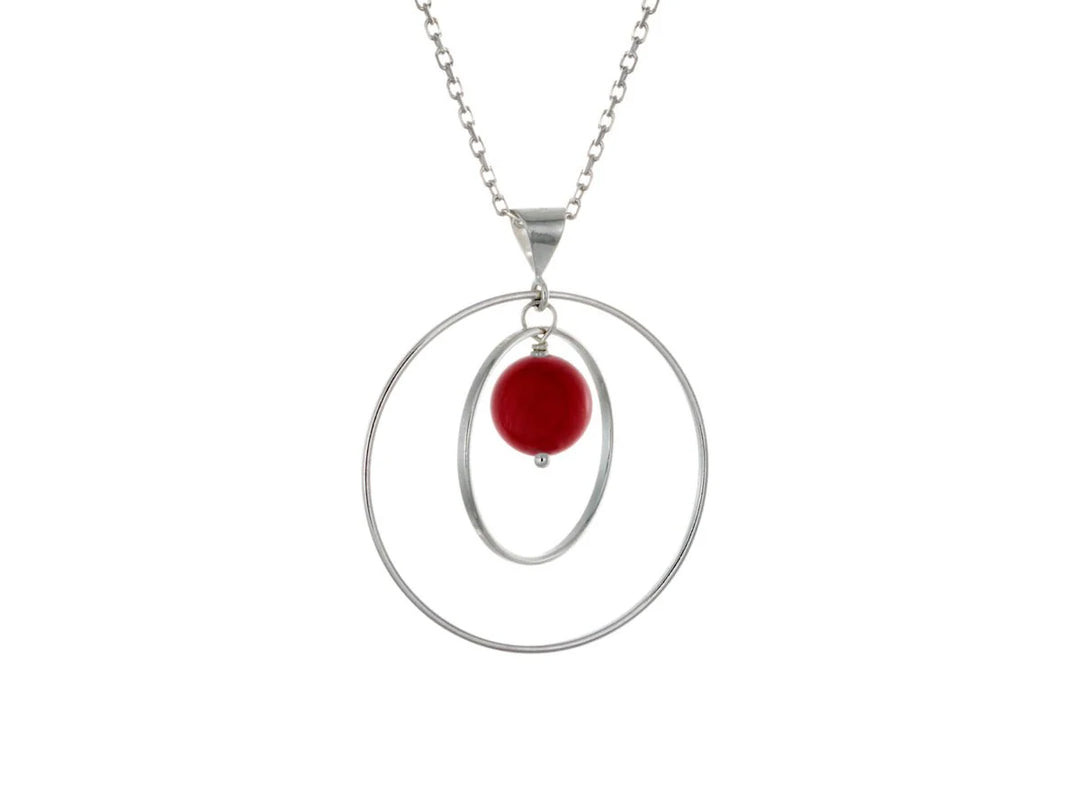This sea bamboo necklace has a large sterling silver hoop with a smaller hoop in the middle of it and a sphere shaped red, sea bamboo bead in the center of them. All of these pieces are suspended and can orbit around each other.
