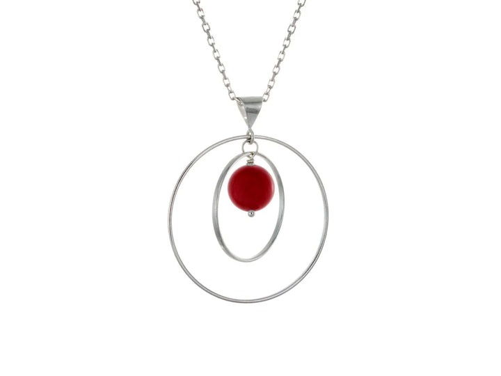 This sea bamboo necklace has a large sterling silver hoop with a smaller hoop in the middle of it and a sphere shaped red, sea bamboo bead in the center of them. All of these pieces are suspended and can orbit around each other.